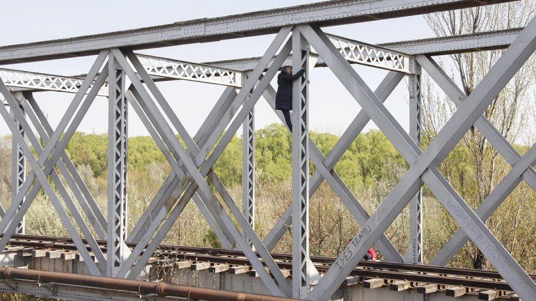 La mujer colgada del puente ferroviario ya está fuera de peligro