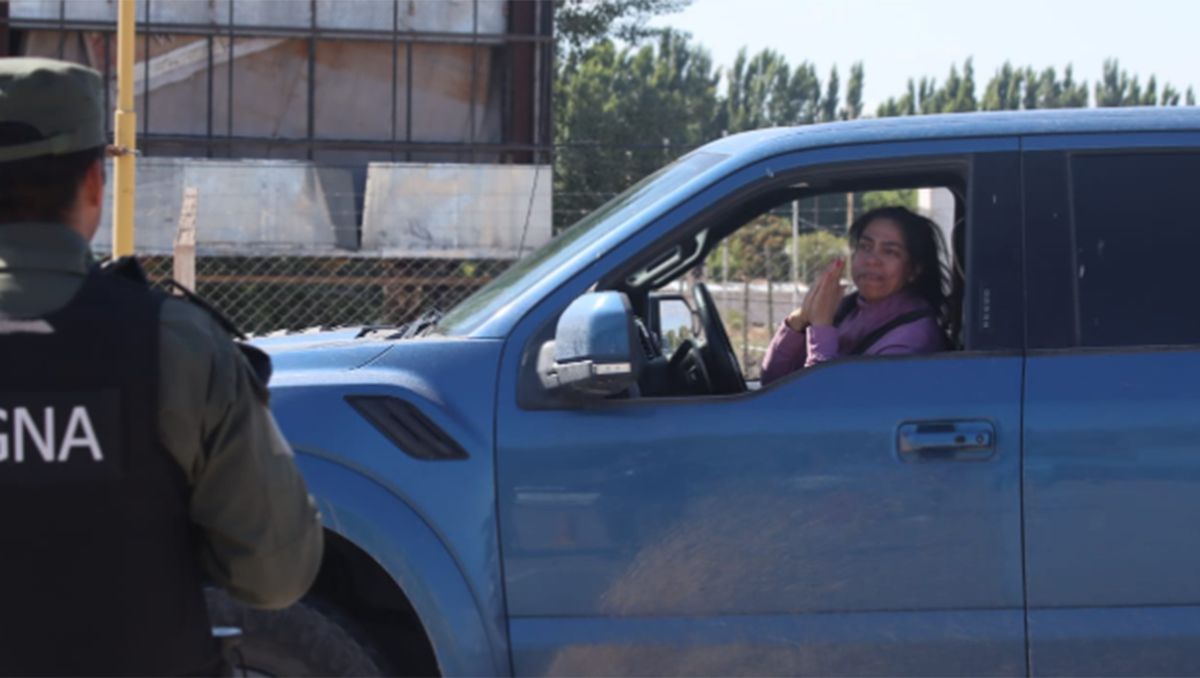 Una vecina le ruega a un gendarme que la deje avanzar y le pide a los piqueteros que levanten. Foto Anahí Cárdena.