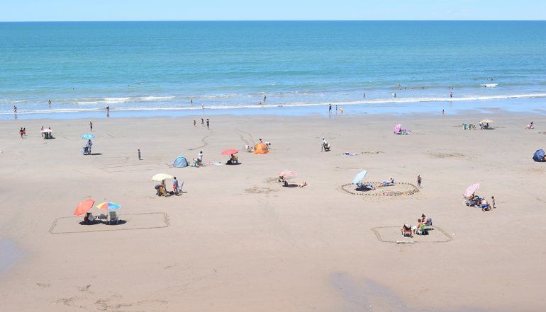 Veraneantes marcan su sector de playa para mantener la distancia sugerida para frenar el Covid. 