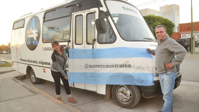 Claudia y Juan, en Fernández Oro, con su Motorhome y la bandera. Foto Antonio Spagnuolo.