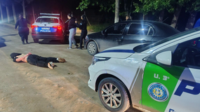 El auto VW Voyage en el que escaparon los tres sospechosos. En la imagen aparece en el piso uno de los detenidos, y una mujer que también fue demorada.&nbsp;