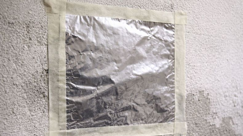 Una lámina de aluminio sellada sobre la pared permite identificar si la humedad proviene del interior del muro o del ambiente.