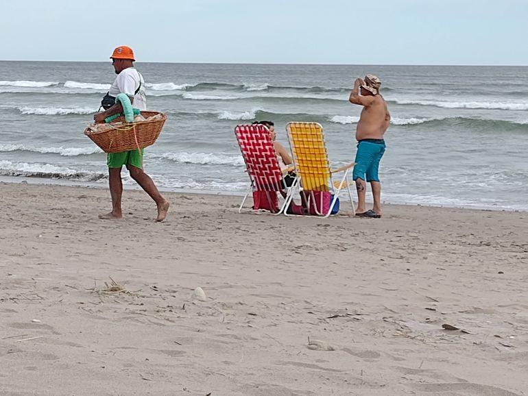 Vendedores en la playa, dejando surco en la arena. Partes del paisaje.