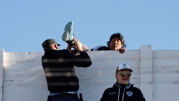 Un policía forcejea con uno de los hinchas que siguió el parido desde afuera.