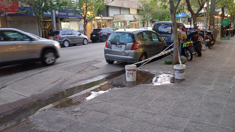 Los vecinos improvisan señalización sobre los brotes de agua potable que emergen en las veredas de calle Roca.