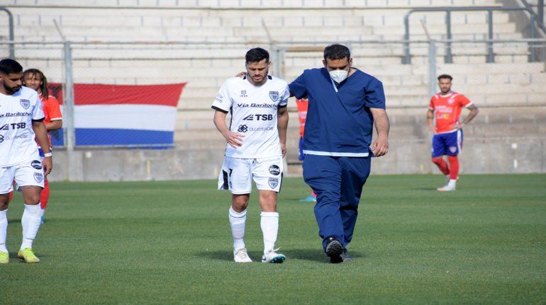 Trecco dejando el campo de juego en San Juan acompañado por un médico.
