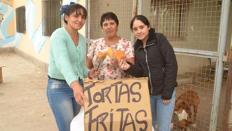 Violeta junto a Vero -a su izquierda- y a otra fiel integrante de su familia vendiendo trotas fritas en la puerta de la escuela. Violeta junto a Vero -a su izquierda- y a otra fiel integrante de su familia vendiendo trotas fritas en la puerta de la escuela.