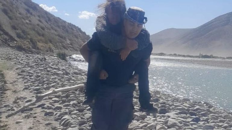 Policía carga a la mujer encontrada en el río Neuquén. Foto gentileza.