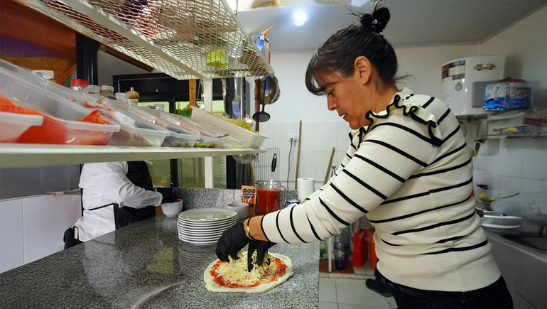 Doris amasando las pizzas que cocina Rubén.