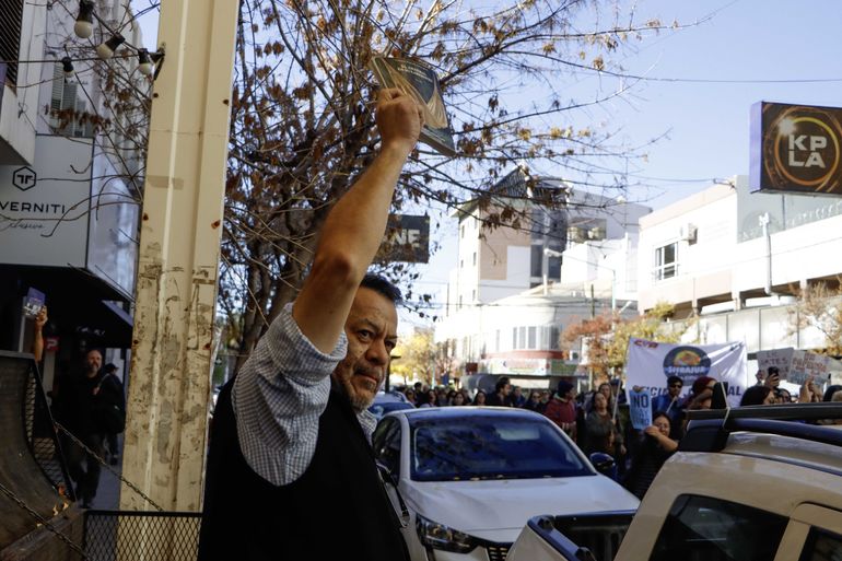 Libro en alto y el apoyo de uno de los comerciantes del centro a los estudiantes. Foto: Anah&iacute; C&aacute;rdena