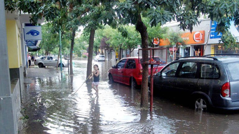 Chapoteo inocente. &nbsp;La niña juega a hacer circular el agua en una laguna.