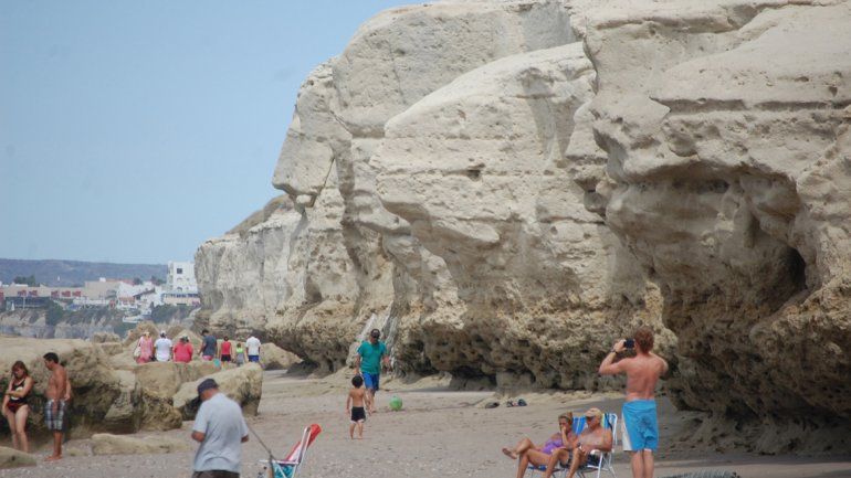 Muchos bañistas buscan la sombra y de paso contemplan el arte del mar sobre la piedra.