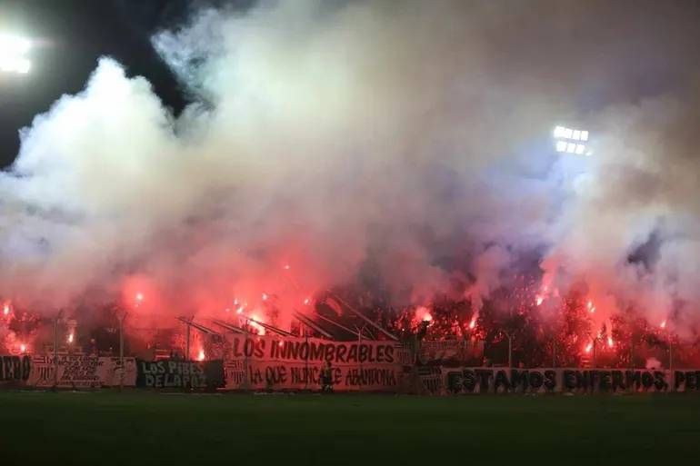 Humo y bengalas en el sector ocupado por Los Innombrables en La Visera. Fue ante Sol de Mayo.