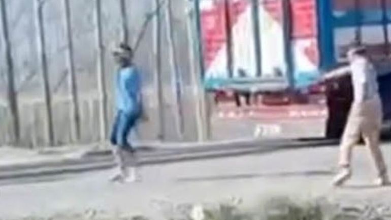 El momento en que dispara el pistolero. El balazo le dio en el abdomen al otro hombre vestido de azul. 