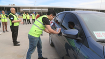 Un inspector, colocando la faja de clausura a un vehículo.