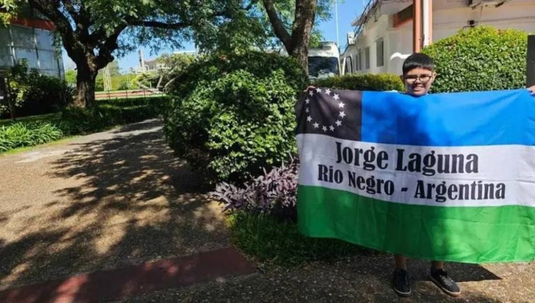 Feliz desplegando la bandera de Río Negro.