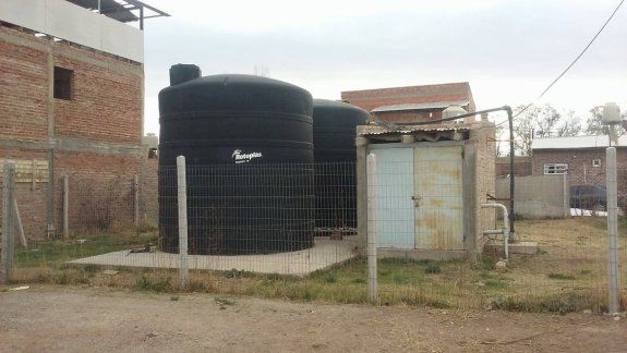 El agua se extrae de un pozo y se almacena en dos grandes tanques.