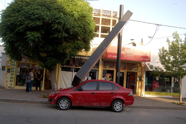 Cartel comercial cayó sobre un auto estacionado