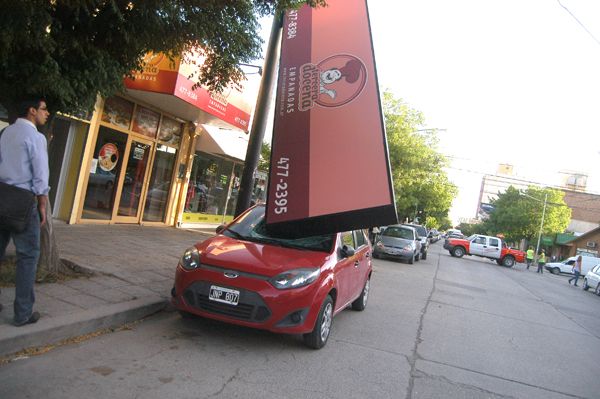 Cartel comercial cayó sobre un auto estacionado