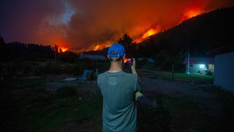 Los vecinos realizan corta fuego para proteger sus casas de las llamas. 