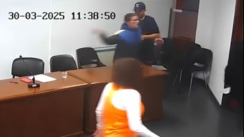 El momento en que el detenido le arroja al micrófono al juez, causándole una fractura de muñeca. 