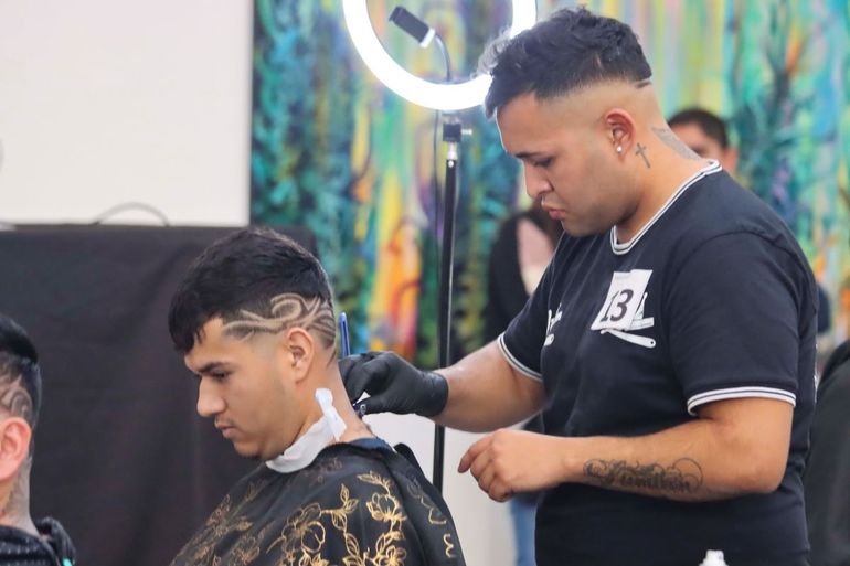 Alumnos de un curso de barbería realizan cortes de pelo gratis.