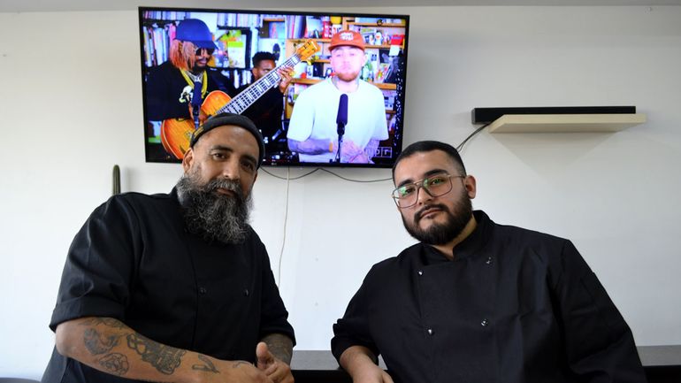 Junto a uno de sus ayudantes en la barbería.