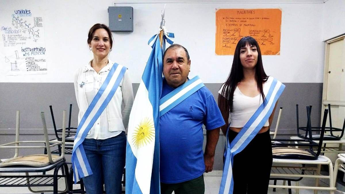 Carlos luce con orgullo la bandera en un reciente acto en la escuela.