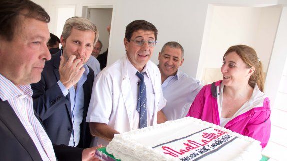 El doctor Alejandro Schroeder, el ministro Rogelio Frigerio y el gobernador Alberto Weretilneck se preparan para compartir una torta en la cooperativa.