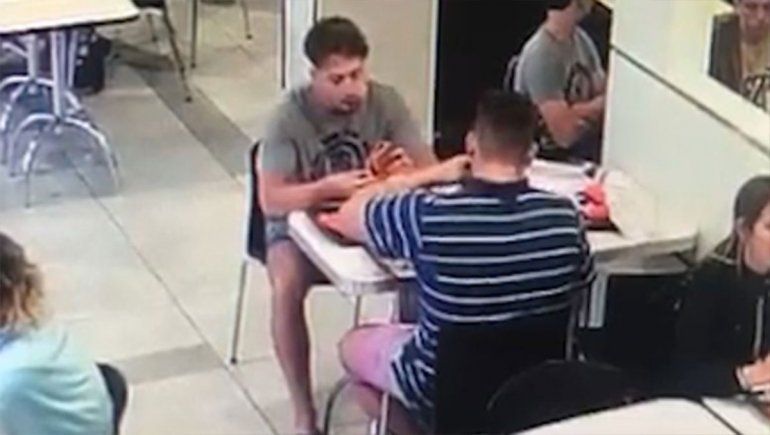 Los rugbiers M&aacute;ximo Thomsen y Lucas Pertossi comen en un local de comidas r&aacute;pidas