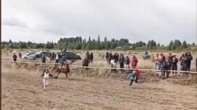 Una imagen impactante. Los niños atraviesan la pista entre caballos que se desplazan a toda velocidad.