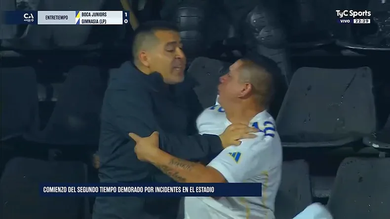 Juan Román Riquelme intentando frenar a un hincha de Boca que se dirigía a la tribuna de Gimnasia.