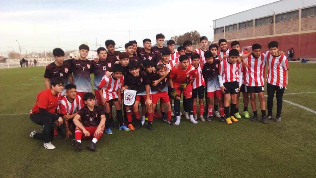 Huracán de Trelew y su plantel junto a los chicos de Los Humildes. Foto: gentileza&nbsp;